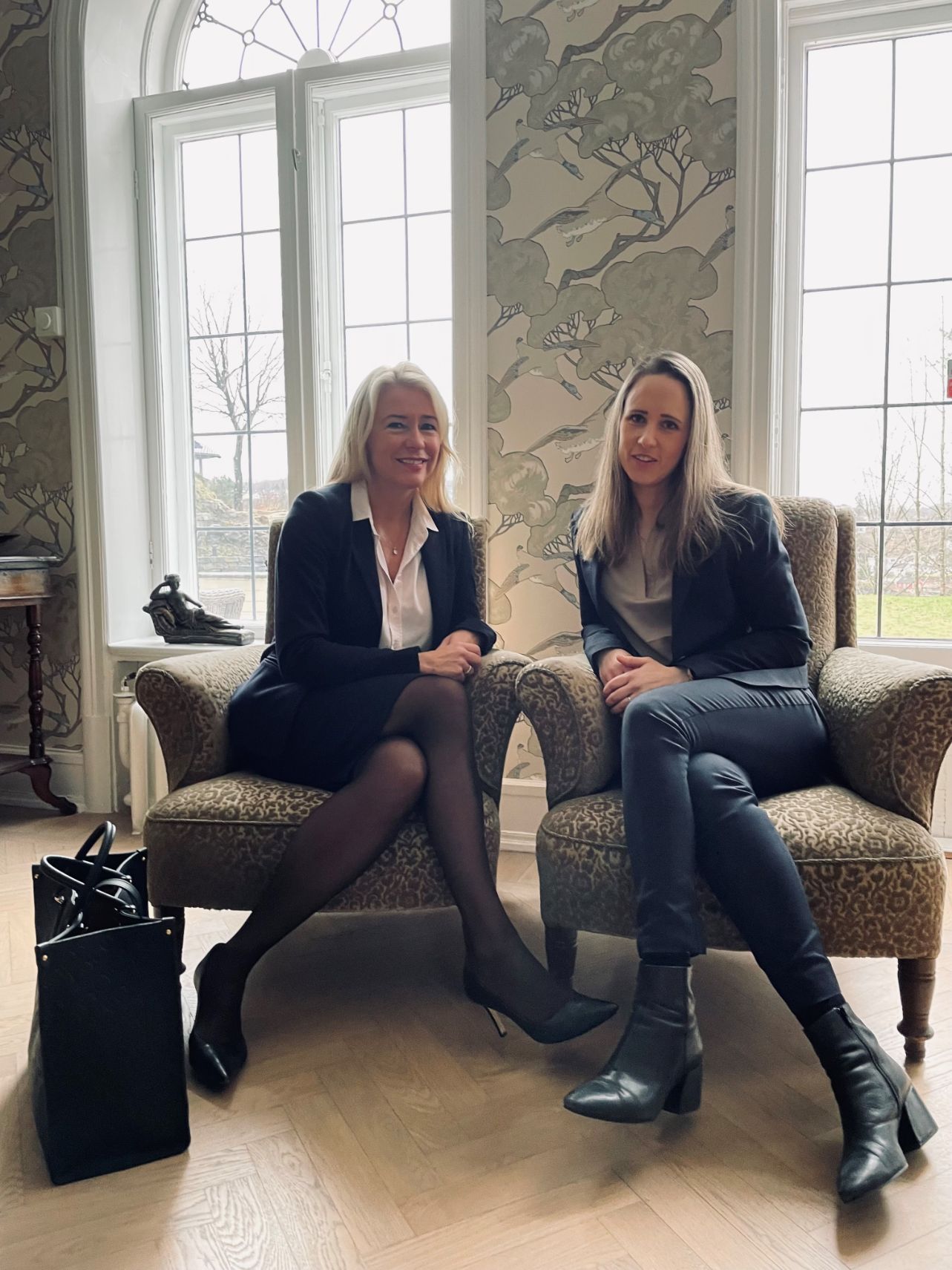 To kvinner sitter på stoler